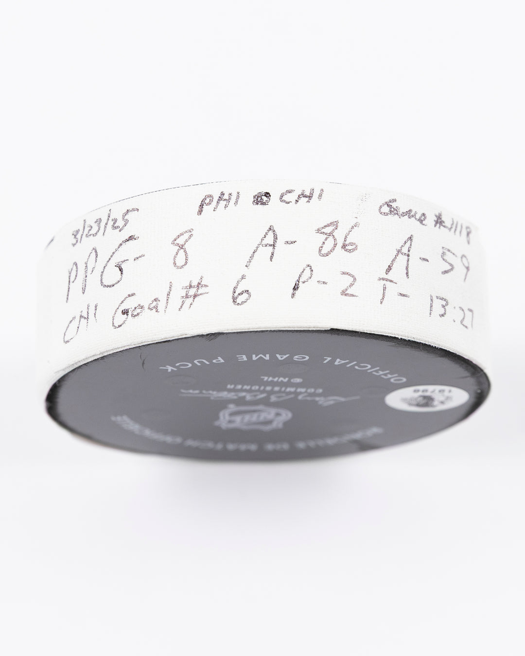 official hockey goal puck scored by Chicago Blackhawks player Ryan Donato on 3/23/25 - tape detail lay flat