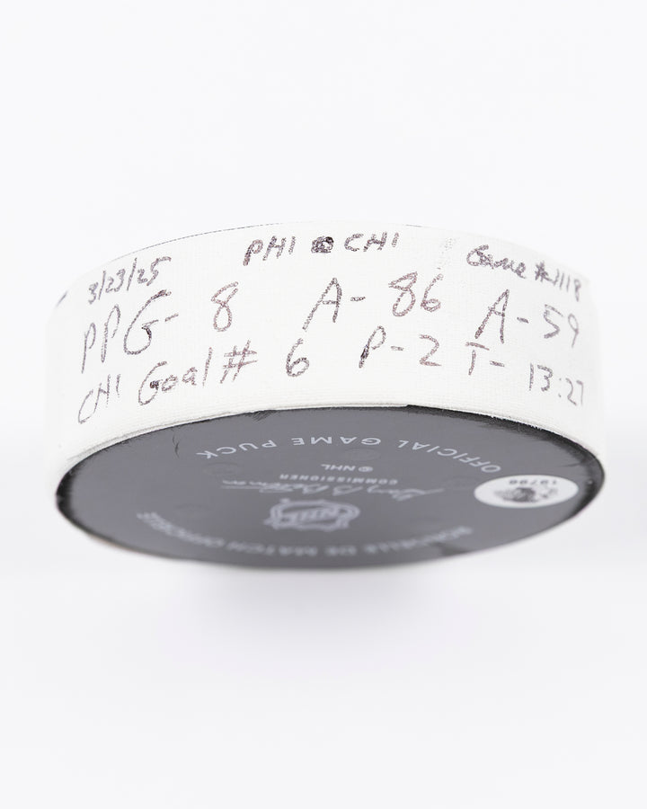 official hockey goal puck scored by Chicago Blackhawks player Ryan Donato on 3/23/25 - tape detail lay flat