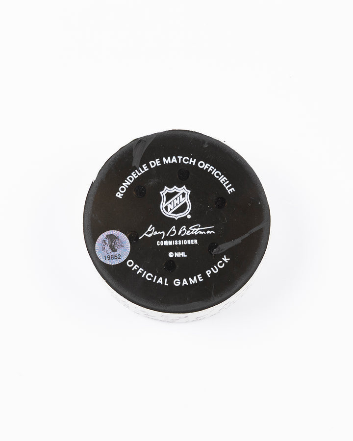 official hockey goal puck used by Chicago Blackhawks player Tyler Bertuzzi on 3/26/25 - back lay flat