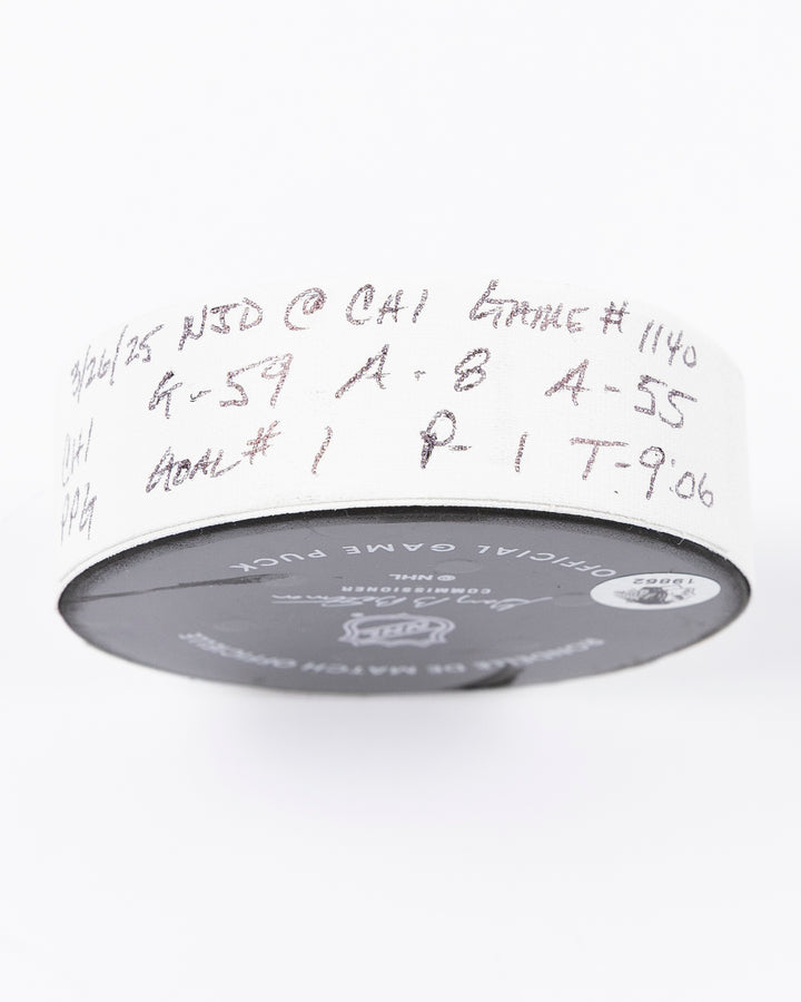 official hockey goal puck used by Chicago Blackhawks player Tyler Bertuzzi on 3/26/25 - tape detail lay flat