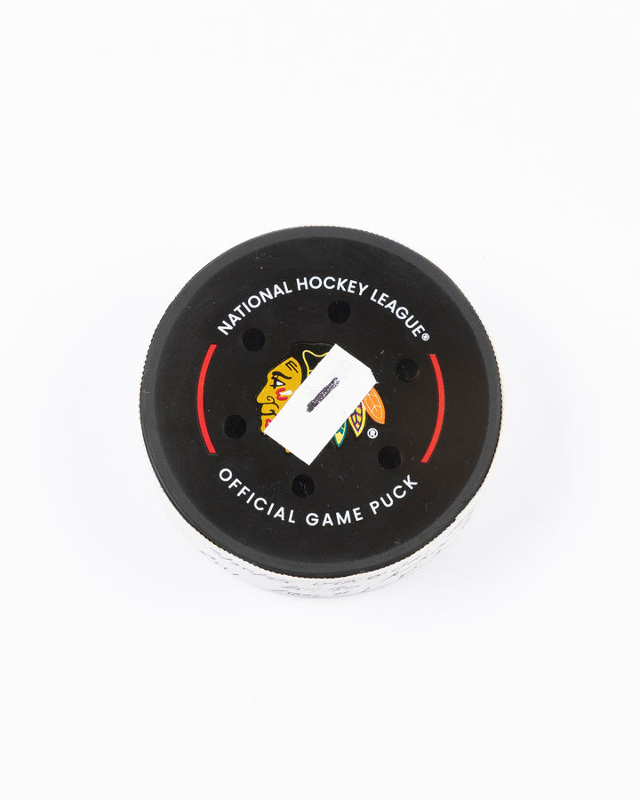 official hockey goal puck scored by Chicago Blackhawks player Joe Veleno on 3/28/25 - front lay flat