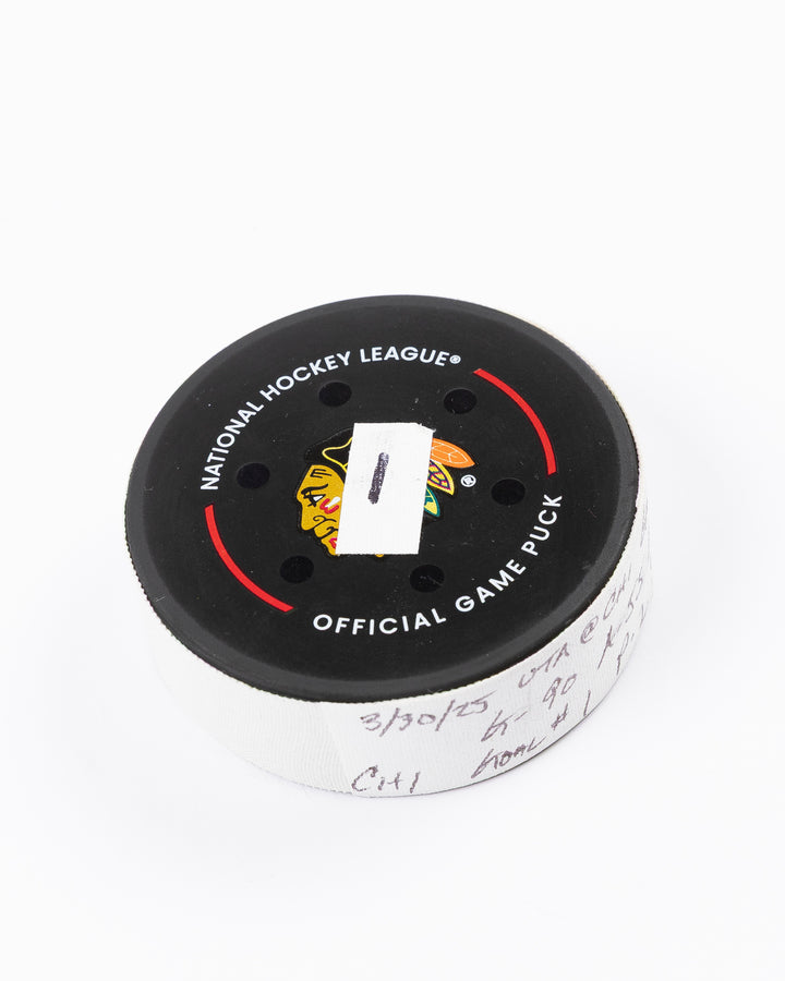 official hockey goal puck scored by Chicago Blackhawks player Joe Veleno on 3/28/25 - front angle lay flat