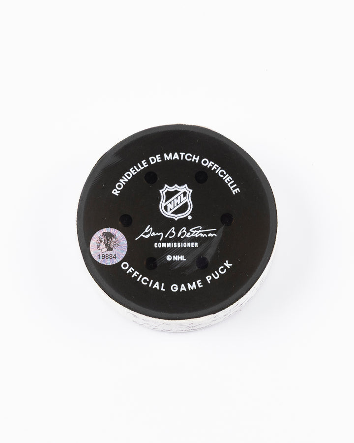 official hockey goal puck scored by Chicago Blackhawks player Joe Veleno on 3/28/25 - back lay flat