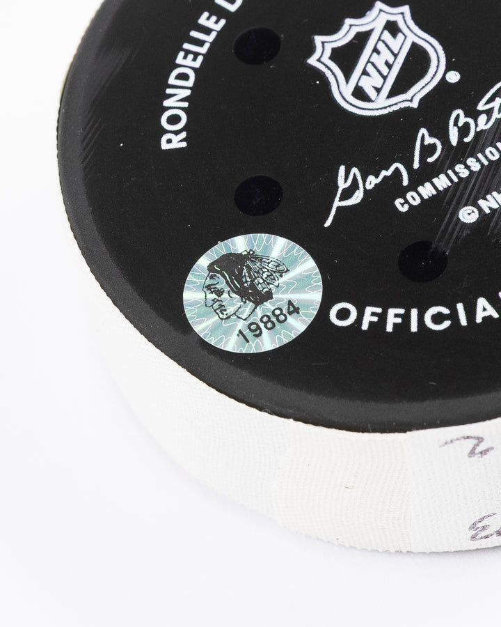 official hockey goal puck scored by Chicago Blackhawks player Joe Veleno on 3/28/25 - hologram sticker detail lay flat