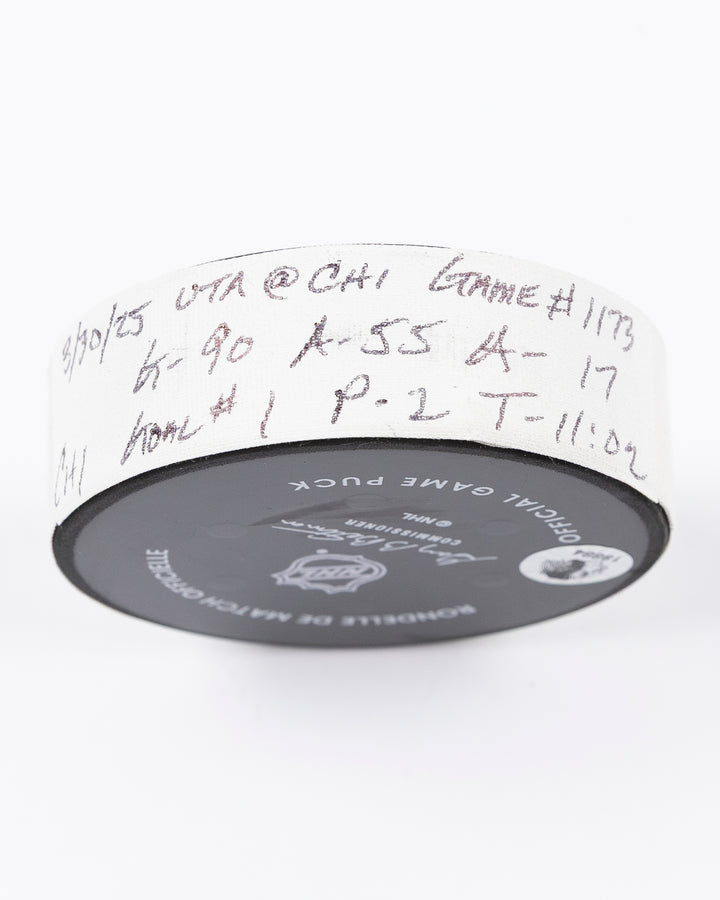 official hockey goal puck scored by Chicago Blackhawks player Joe Veleno on 3/28/25 - tape detail lay flat
