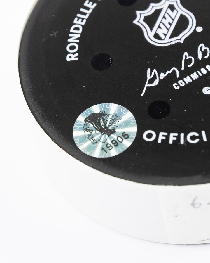 official hockey goal puck scored by Chicago Blackhawks player Ilya Mikheyev on 4/2/25 - hologram sticker detail lay flat