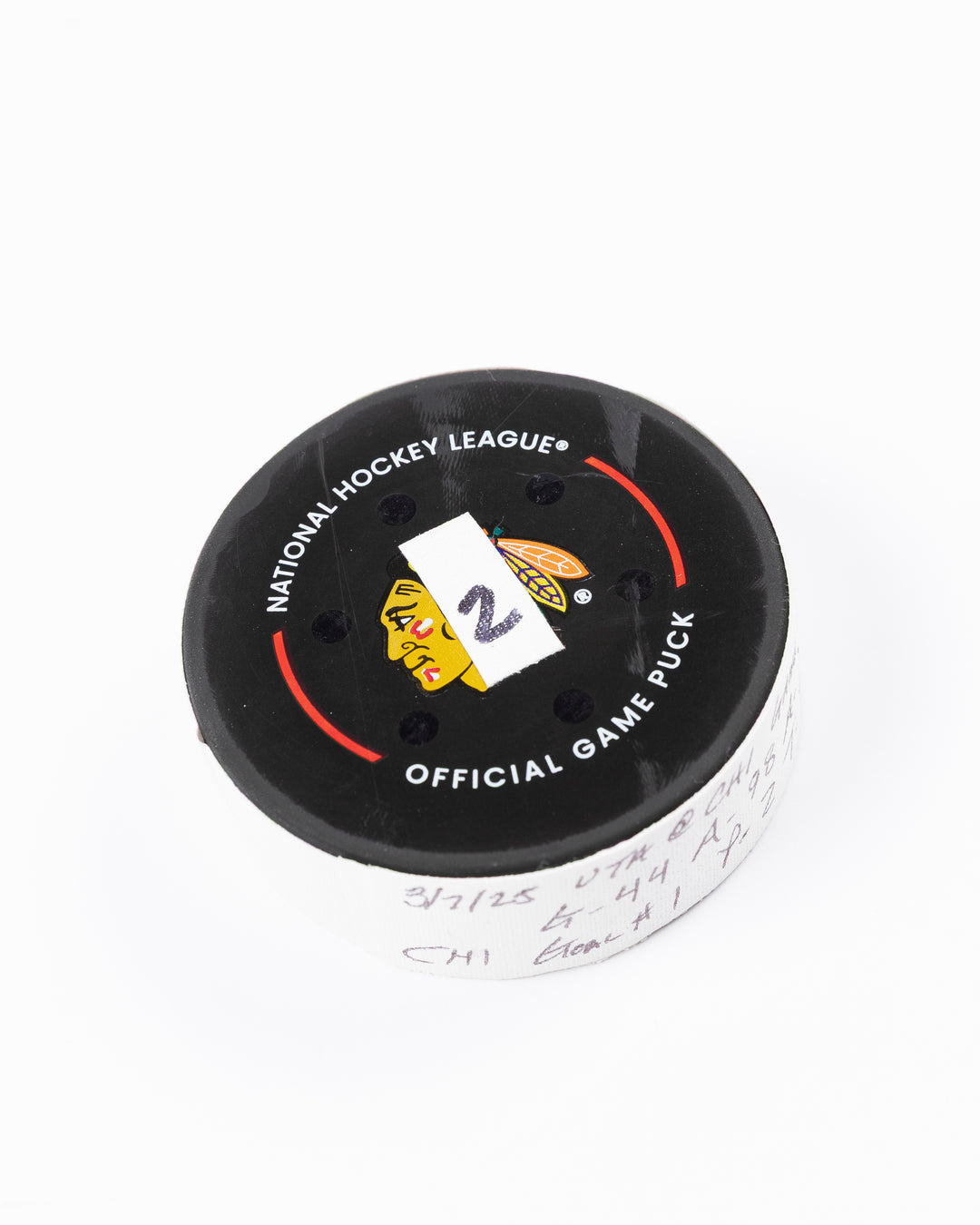 official game used hockey goal puck scored by Chicago Blackhawks player Wyatt Kaiser - front angle lay flat
