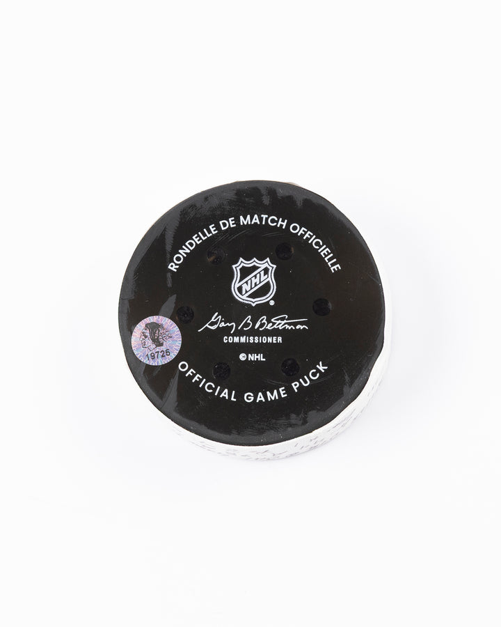 official game used hockey goal puck scored by Chicago Blackhawks player Wyatt Kaiser - back lay flat