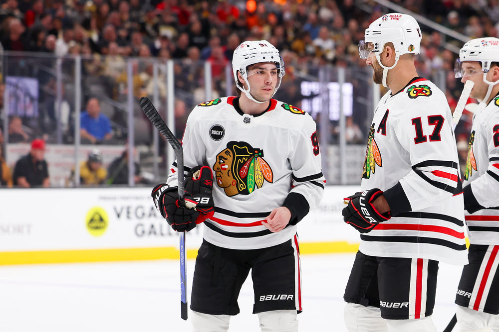 Frank Nazar in white Chicago Blackhawks away uniform with Foligno and Kurashev