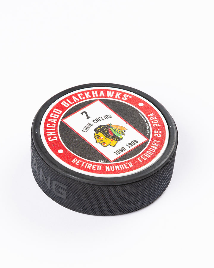 Mustang hockey puck with Chris Chelios retirement banner graphic - detail lay flat