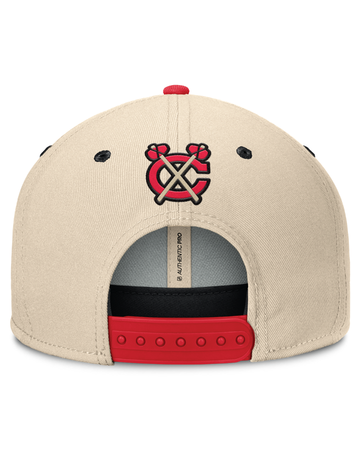 cream and black flat brim Fanatics hat with Chicago Blackhawks script wordmark on front and Winter Classic logo - back angle lay flat