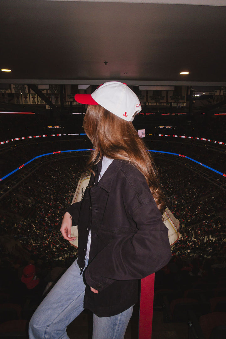 woman wearing two tone red and white Alice & Wonder baseball hat with embroidered CHI detailing on front and Blackhawks wordmark on back