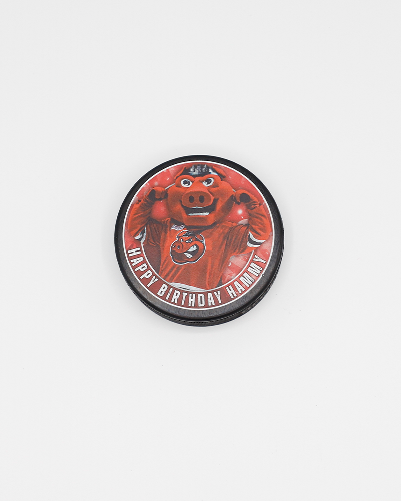 black hockey puck with Happy Birthday Hammy wordmark and photo of Rockford IceHogs mascot Hammy on front - front lay flat