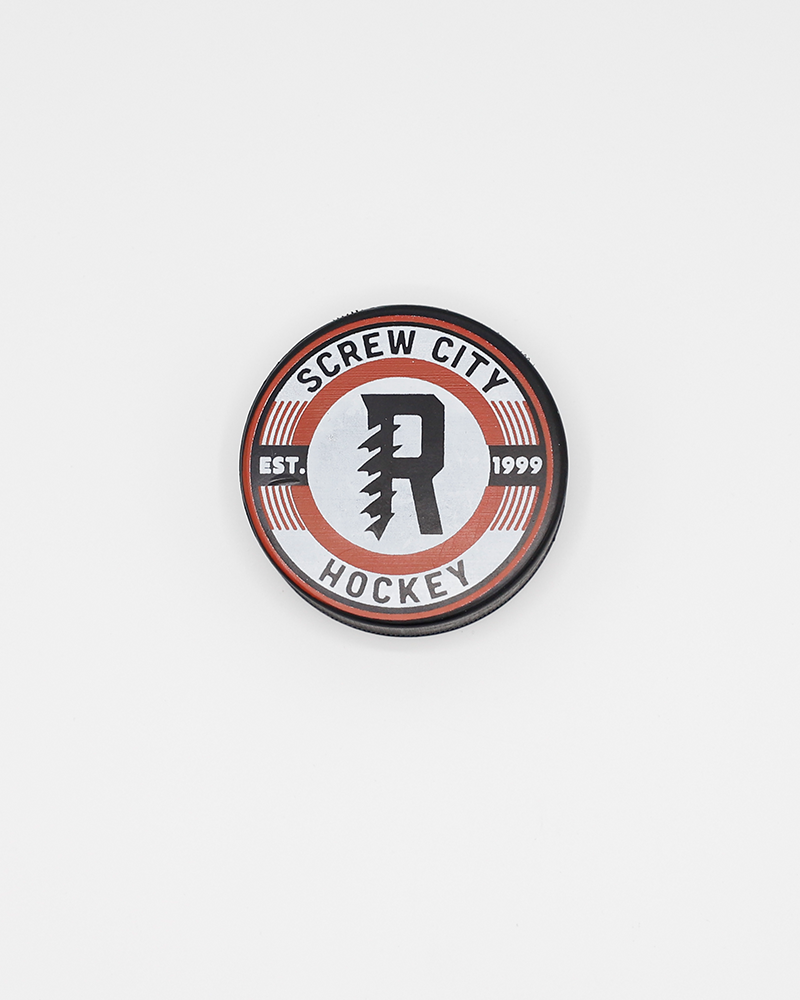 black hockey puck with Screw City Hockey wordmark and R graphic on the front - front lay flat
