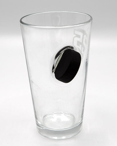 25th anniversary Rockford IceHogs pint glass with puck going through the glass - bac lay flat