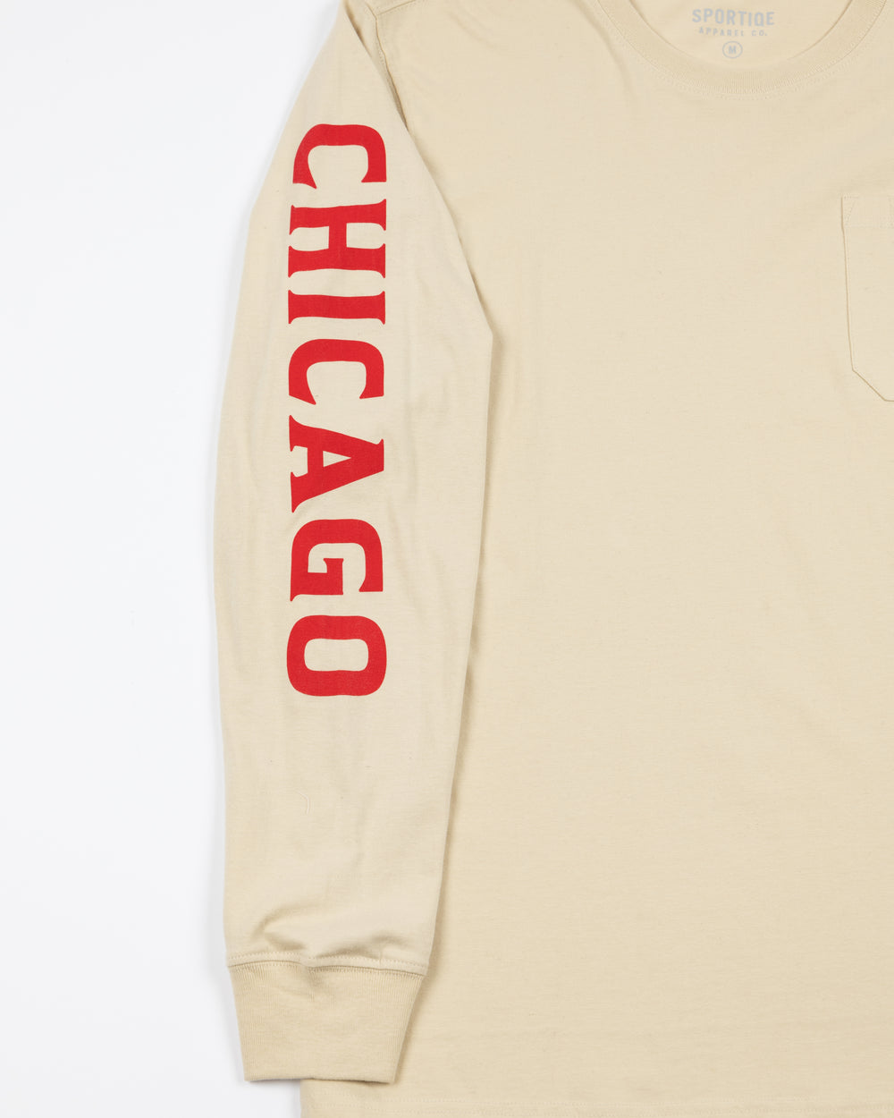 cream long sleeve pocket tee from Sportiqe with Chicago wordmark down right sleeve and Blackhawks tag on left chest pocket - sleeve detail lay flat