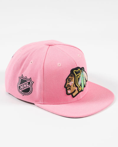 Mitchell & Ness pink snapback with Chicago Blackhawks primary logo embroidered on the front with pink accents - right angle lay flat