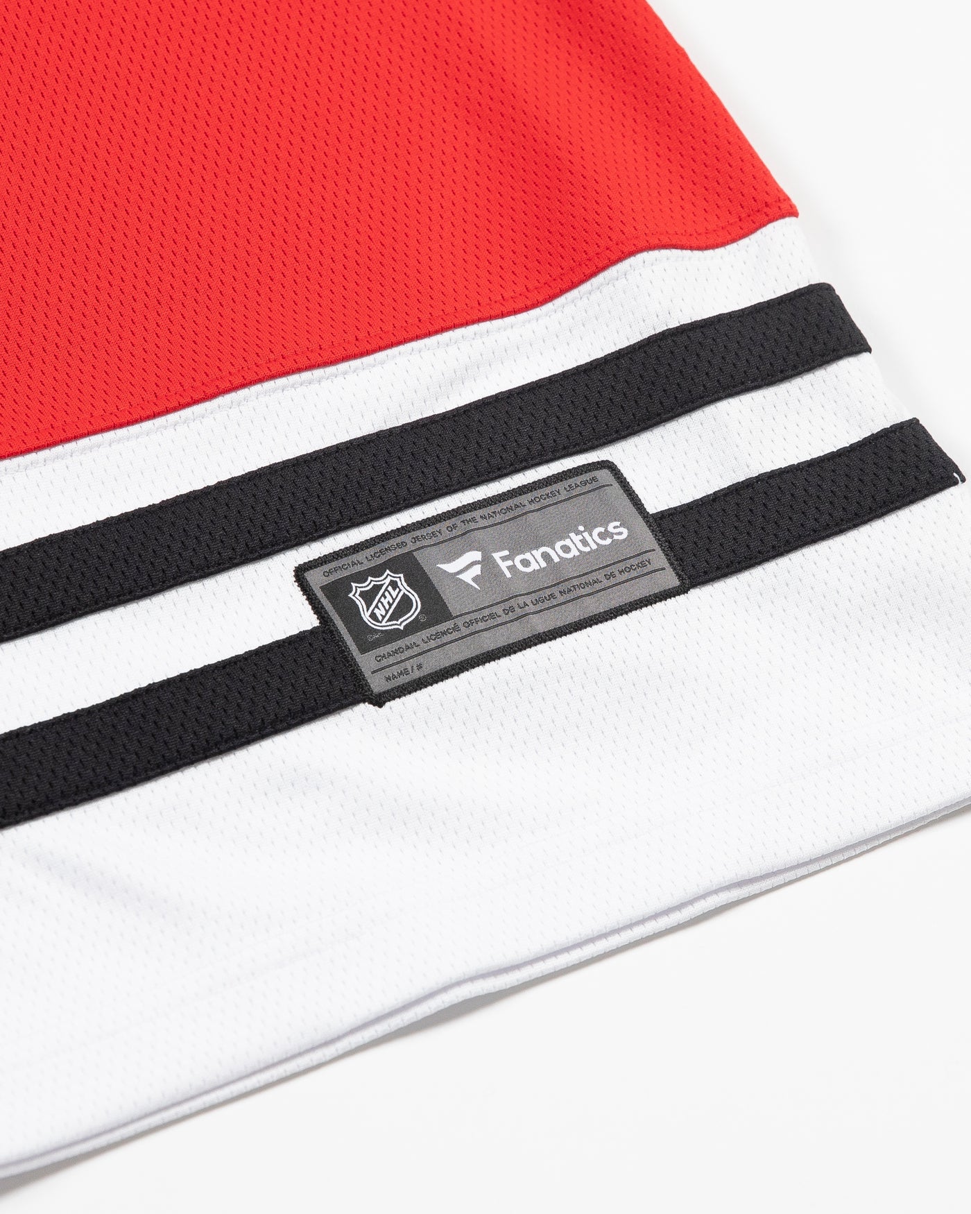 Red Fanatics ladies jersey with Chicago Blackhawks primary logo on front and classic stripes along sleeves and hem - detail hem lay flat