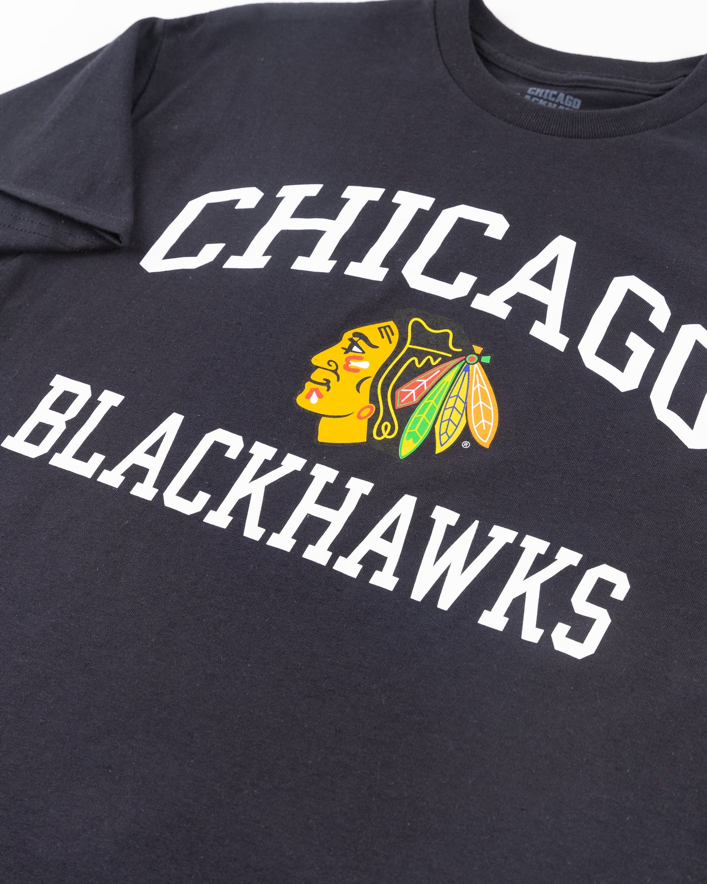 black Chicago Blackhawks short sleeve tee with wordmark and primary logo on chest and secondary logo on left shoulder - detail front lay flat
