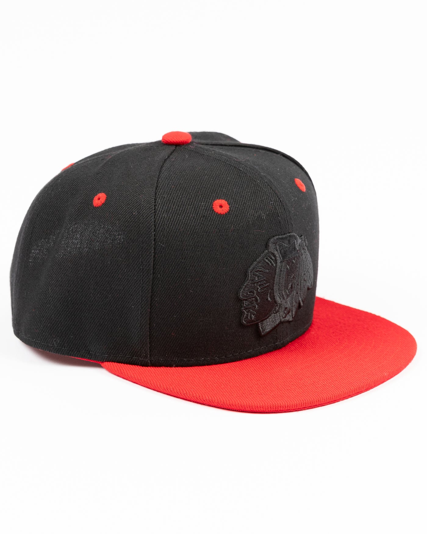 two tone black and red youth snapback cap with Chicago Blackhawks tonal primary logo on front and red wordmark on back - right angle lay flat