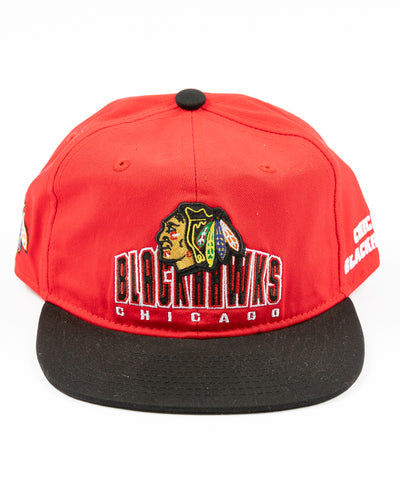 two tone red and black youth snapback cap with Chicago Blackhawks wordmark and primary logo across front - front lay flat