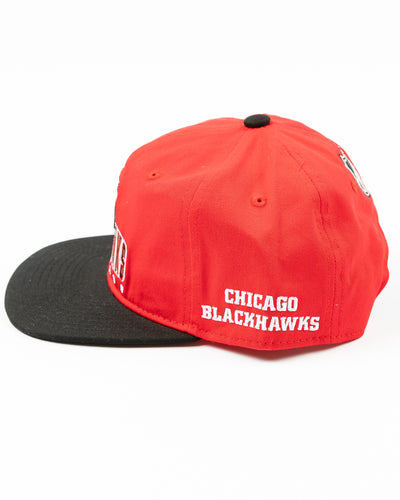 two tone red and black youth snapback cap with Chicago Blackhawks wordmark and primary logo across front - left side lay flat