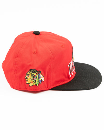 two tone red and black youth snapback cap with Chicago Blackhawks wordmark and primary logo across front - right side lay flat