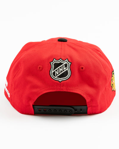 two tone red and black youth snapback cap with Chicago Blackhawks wordmark and primary logo across front - back lay flat