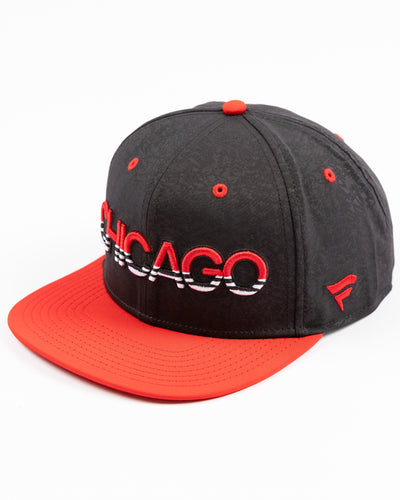 two tone black and red debossed Fanatics snapback cap with Chicago wordmark on front and Chicago Blackhawks primary logo embroidered on right side - left angle lay flat