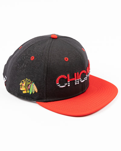 two tone black and red debossed Fanatics snapback cap with Chicago wordmark on front and Chicago Blackhawks primary logo embroidered on right side - right angle lay flat