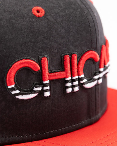 two tone black and red debossed Fanatics snapback cap with Chicago wordmark on front and Chicago Blackhawks primary logo embroidered on right side - detail lay flat