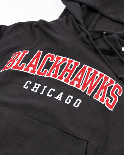 black Champion reverse weave hoodie with Chicago Blackhawks wordmark embroidered on the front - detail lay flat