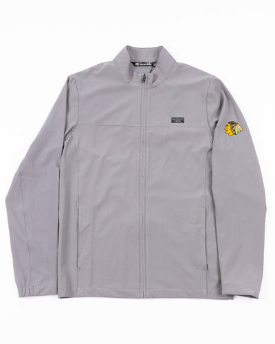 grey TravisMathew full zip jacket with Chicago Blackhawks primary logo embroidered on left shoulder - front lay flat