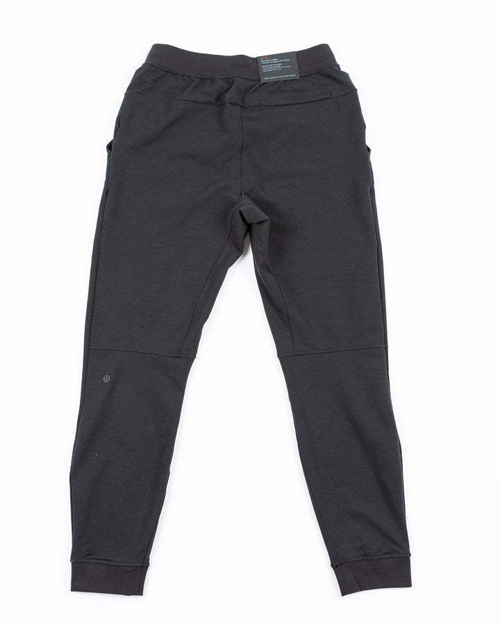 black lululemon joggers with tonal Chicago Blackhawks primary logo printed on left leg - back lay flat