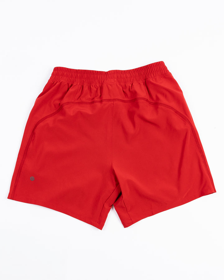red lululemon men's shorts with Chicago Blackhawks wordmark printed on left leg - back lay flat