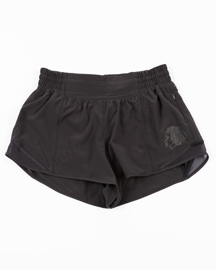 black lululemon women's running shorts with tonal Chicago Blackhawks primary logo printed on left leg - front lay flat