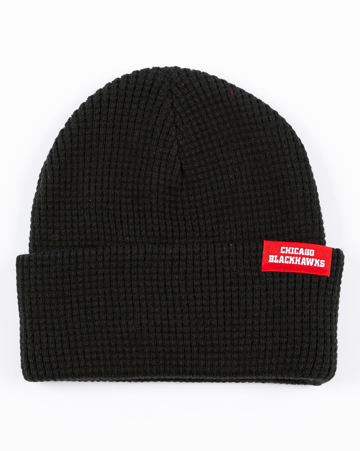 black Mitchell & Ness waffle knit beanie with Chicago Blackhawks wordmark tag adorning cuff - front lay flat