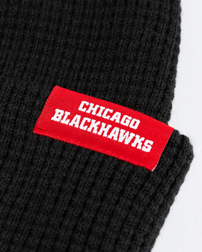 black Mitchell & Ness waffle knit beanie with Chicago Blackhawks wordmark tag adorning cuff - detail lay flat
