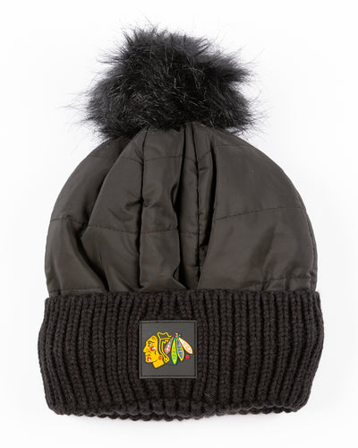black Zoozatz pom knit hat with puffer jacket fabric on front and knit cuff with Chicago Blackhawks rubberized patch on front - front lay flat 