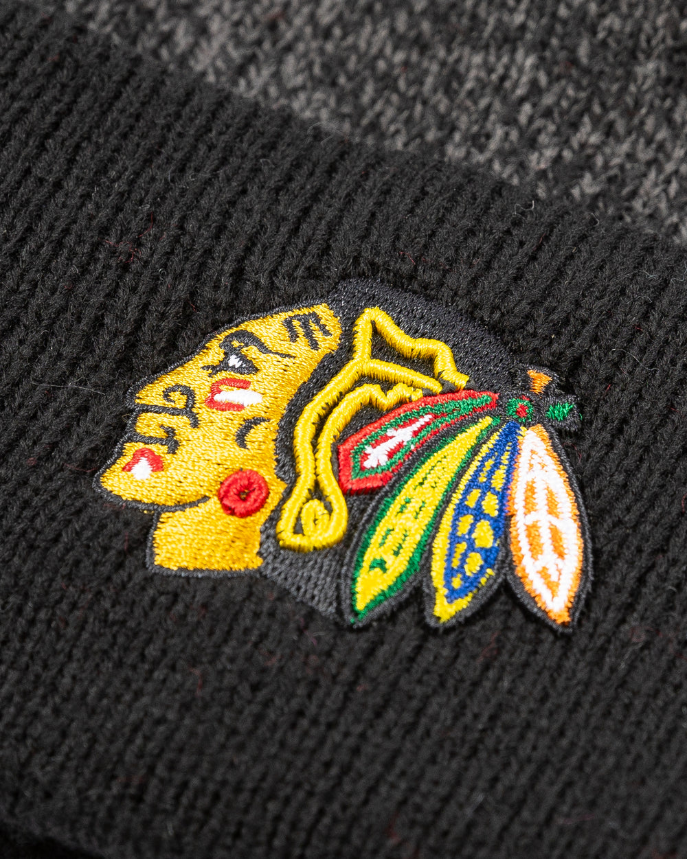 black and grey color blocked knit hat with Chicago Blackhawks primary logo embroidered on cuff with black pom - detail lay flat