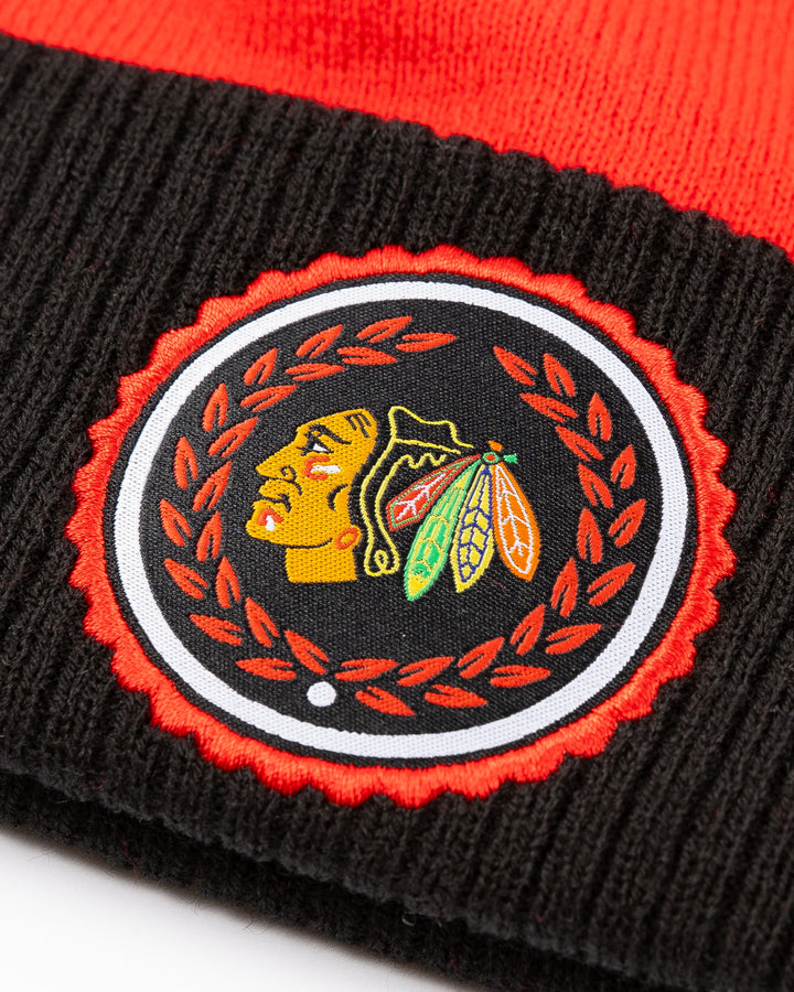 red and black adidas knit pom hat with Chicago Blackhawks primary logo collegiate inspired patch on cuff - detail lay flat