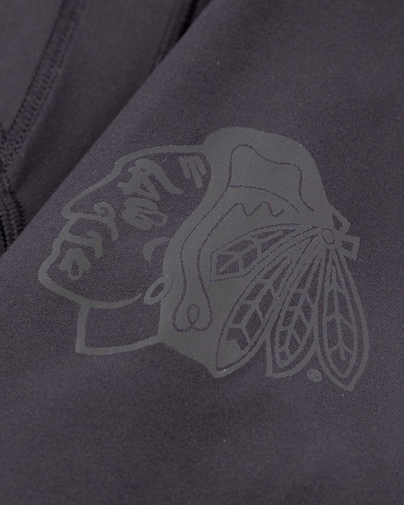 black lululemon hooded jacket with tonal Chicago Blackhawks logo printed on left shoulder - detail lay flat