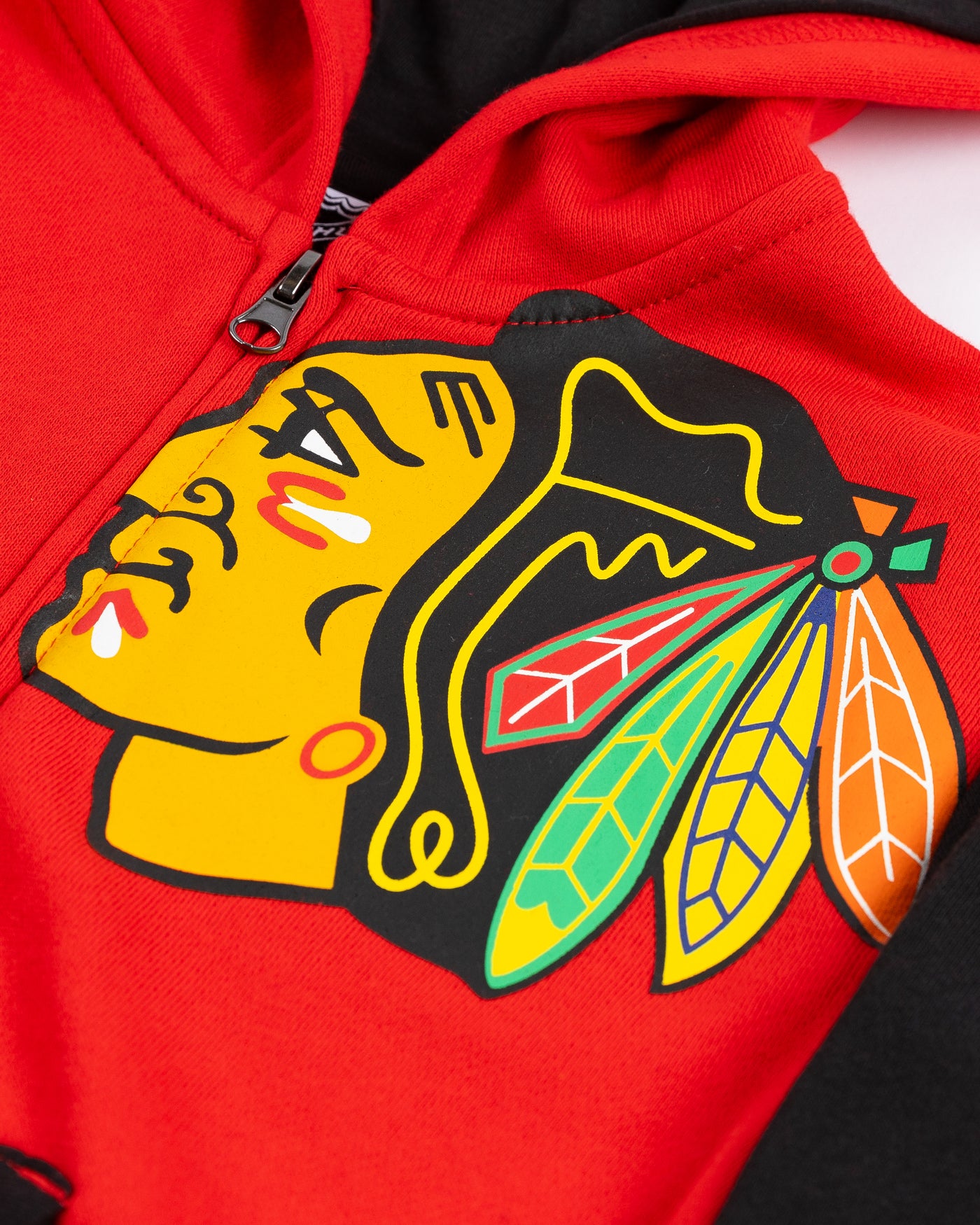 youth Champion zip up hoodie with red and black color block design and Chicago Blackhawks primary logos on left chest and right sleeve - detail lay flat