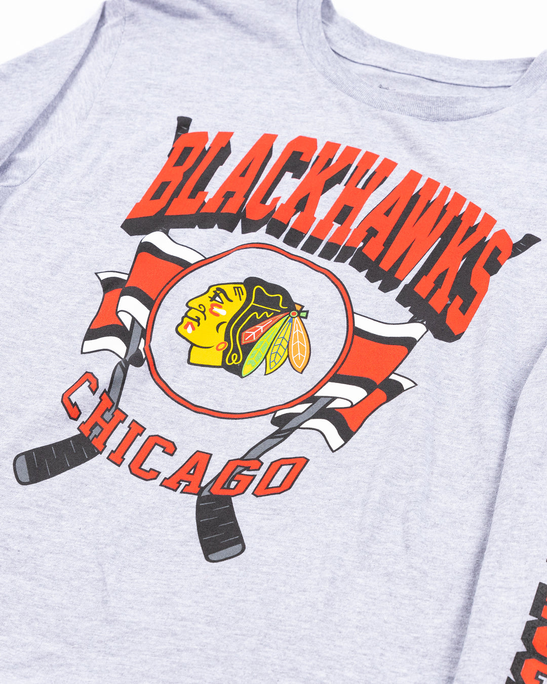 grey youth long sleeve tee with Chicago Blackhawks wodmark on left arm and primary logo hockey sick graphic across chest - detail lay flat