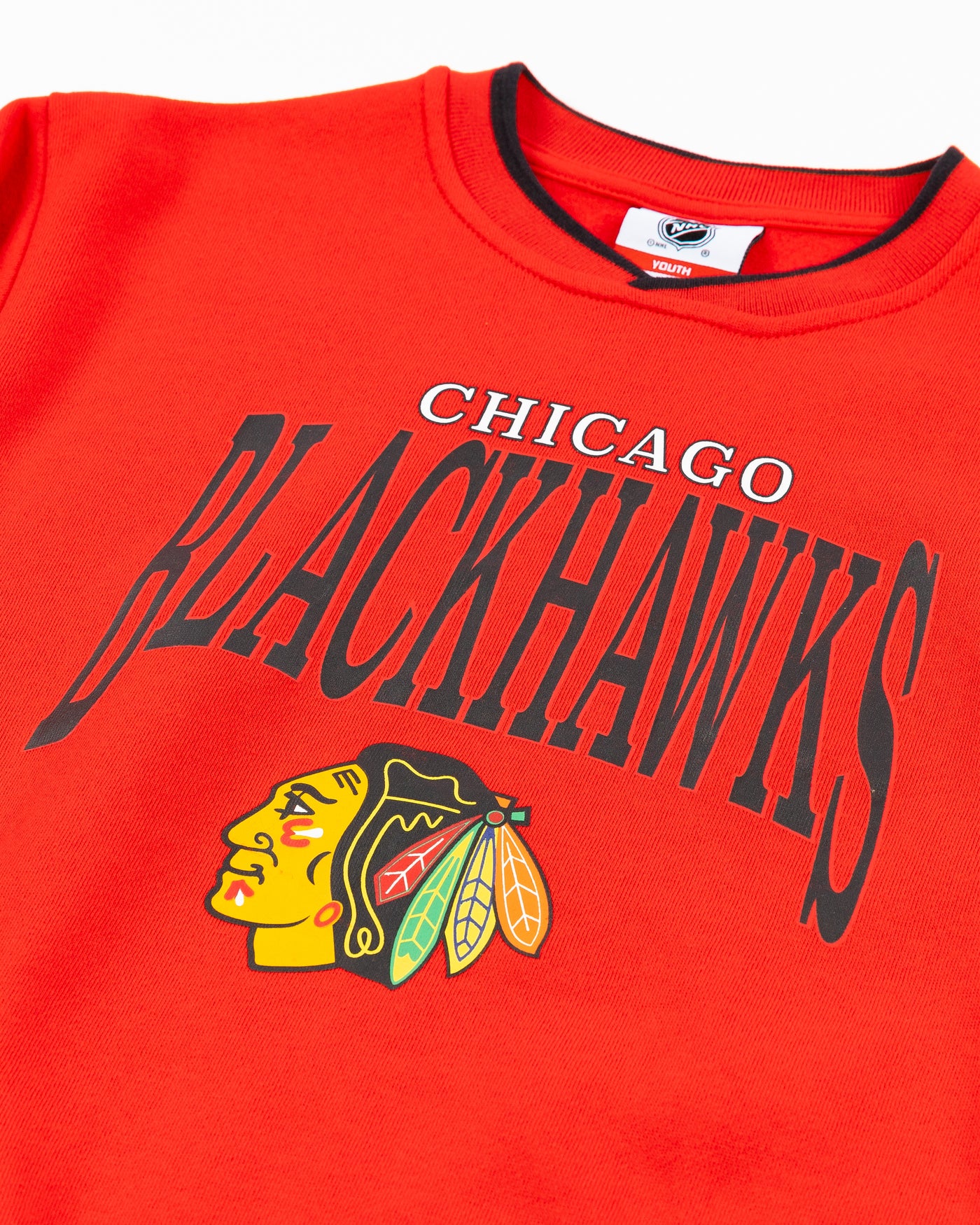 red youth crewneck sweater with Chicago Blackhawks wordmark and primary logo on front - detail lay flat