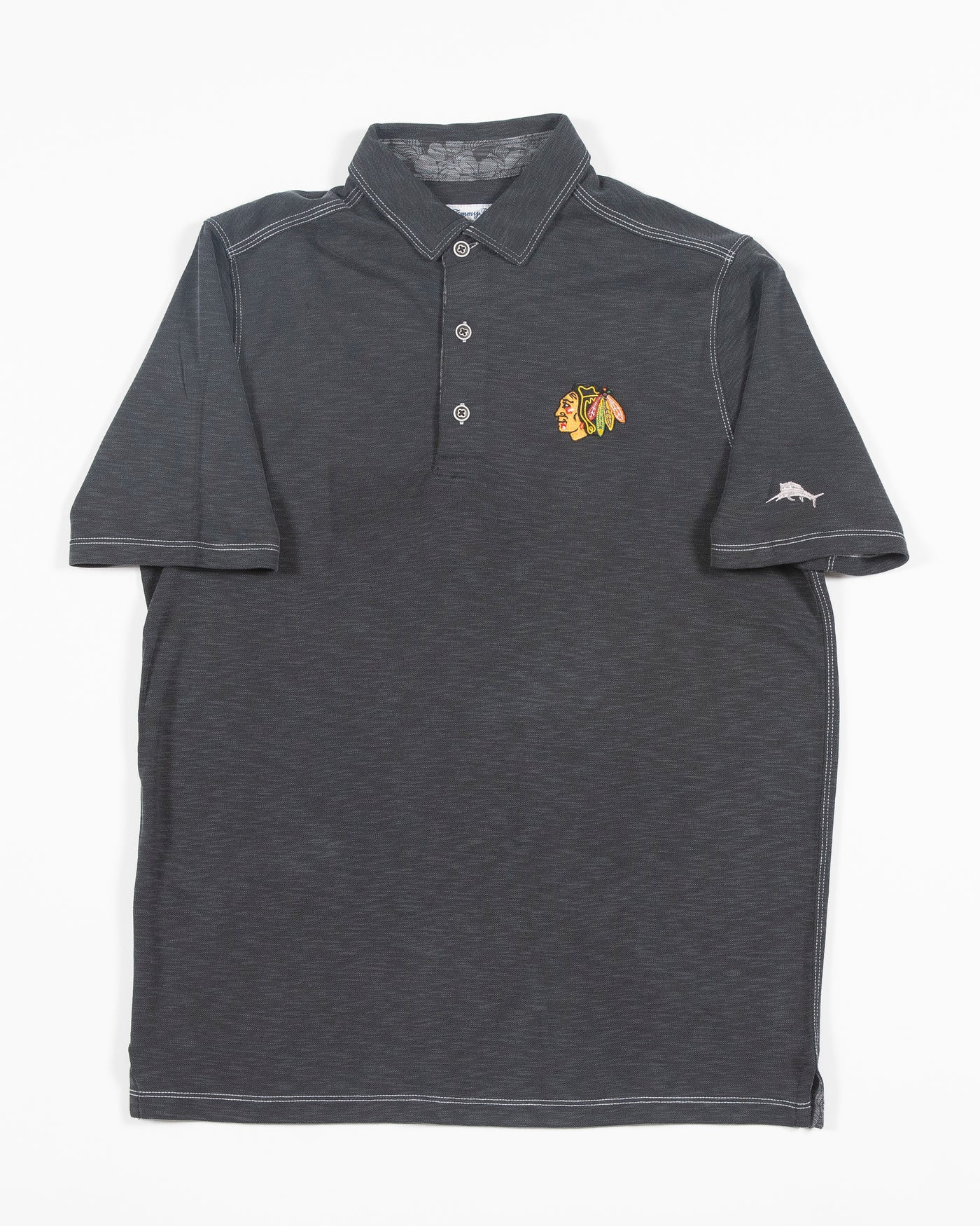 black Tommy Bahama polo with Chicago Blackhawks primary logo embroidered on left chest - front lay flat