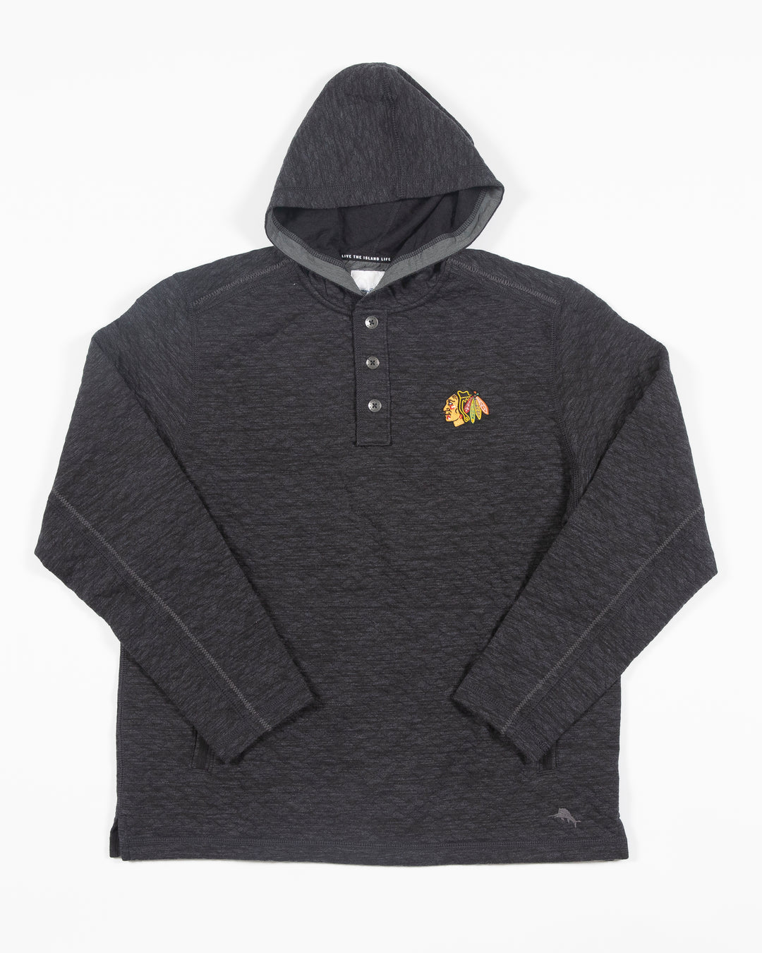 black Tommy Bahama hoodie with half button closure with Chicago Blackhawks primary logo embroidered on left chest - front lay flat