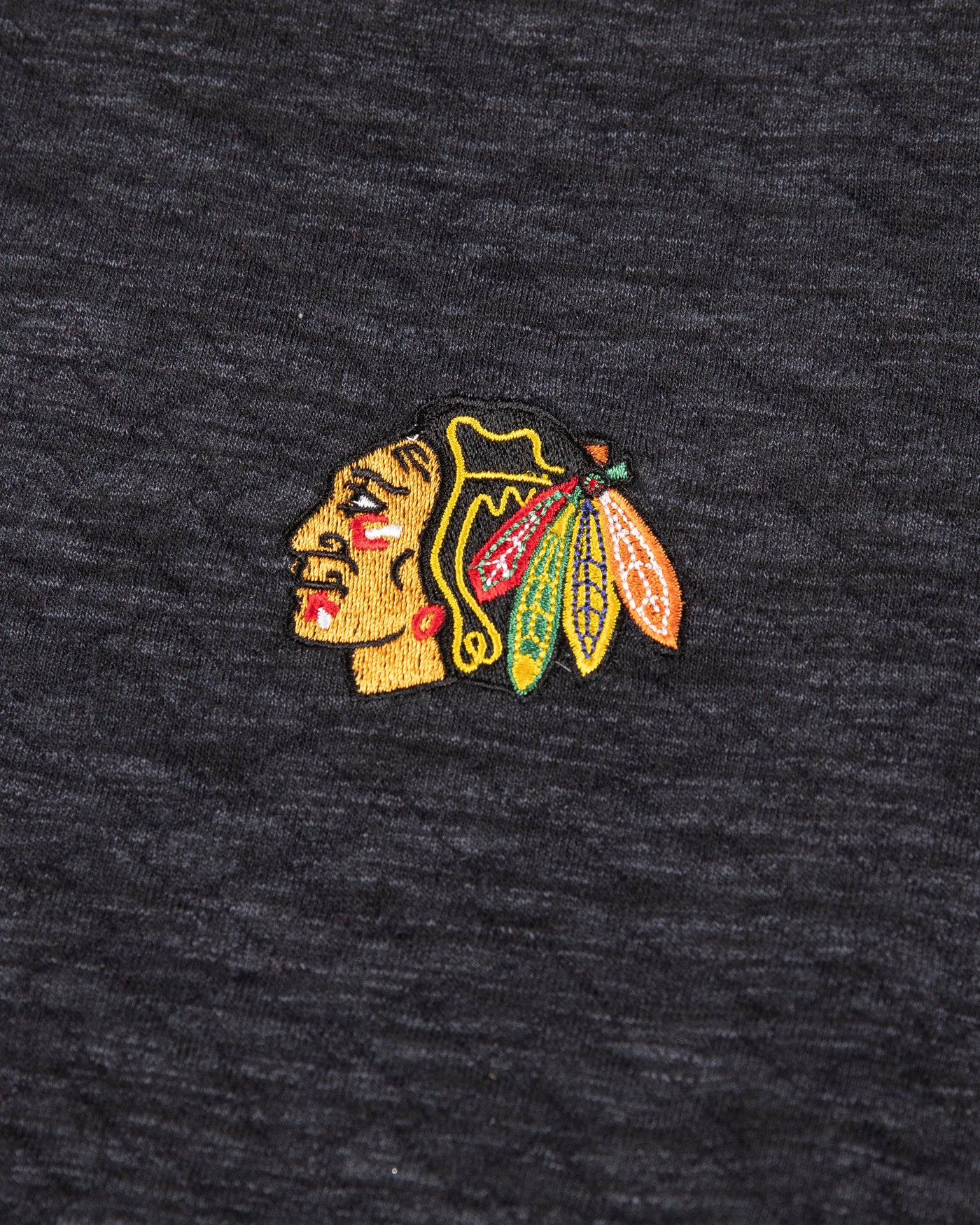 black Tommy Bahama hoodie with half button closure with Chicago Blackhawks primary logo embroidered on left chest - detail logo lay flat