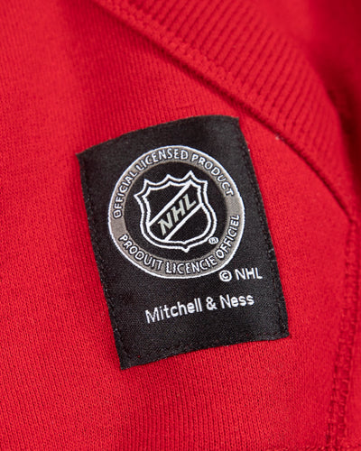 red Mitchell & Ness hoodie with Chicago Blackhawks secondary logo on front, NHL Western Conference patch on left shoulder and Chicago Blackhawks wordmark on hood - NHL tag detail lay flat