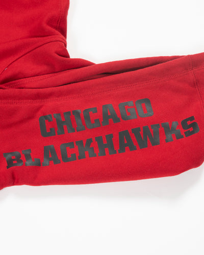 red Mitchell & Ness hoodie with Chicago Blackhawks secondary logo on front, NHL Western Conference patch on left shoulder and Chicago Blackhawks wordmark on hood - hood graphic detail lay flat